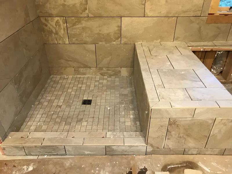 Progress shot of a tile shower with intricate stone work