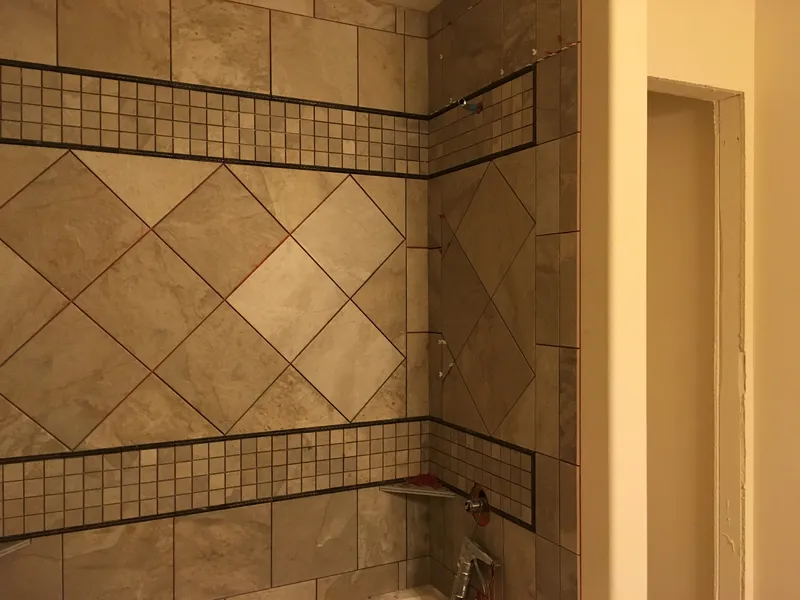Unique tile pattern in a walk in shower with angles and horizontal patterns