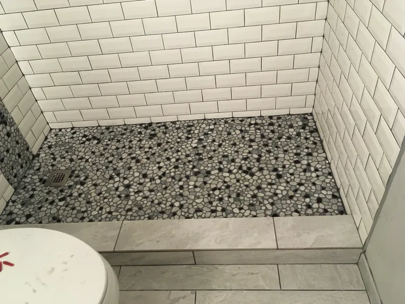 Floor shot of an intricate stone pattern in a walk in shower